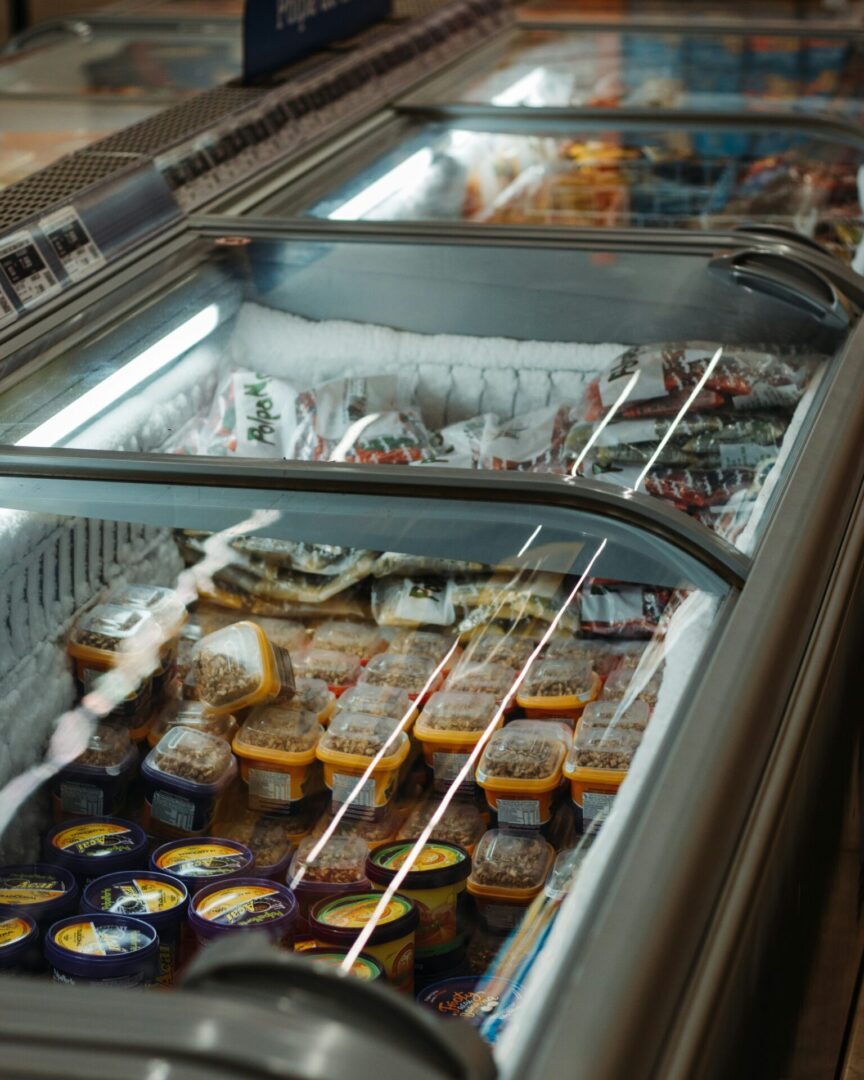 A row of food in an open display case.