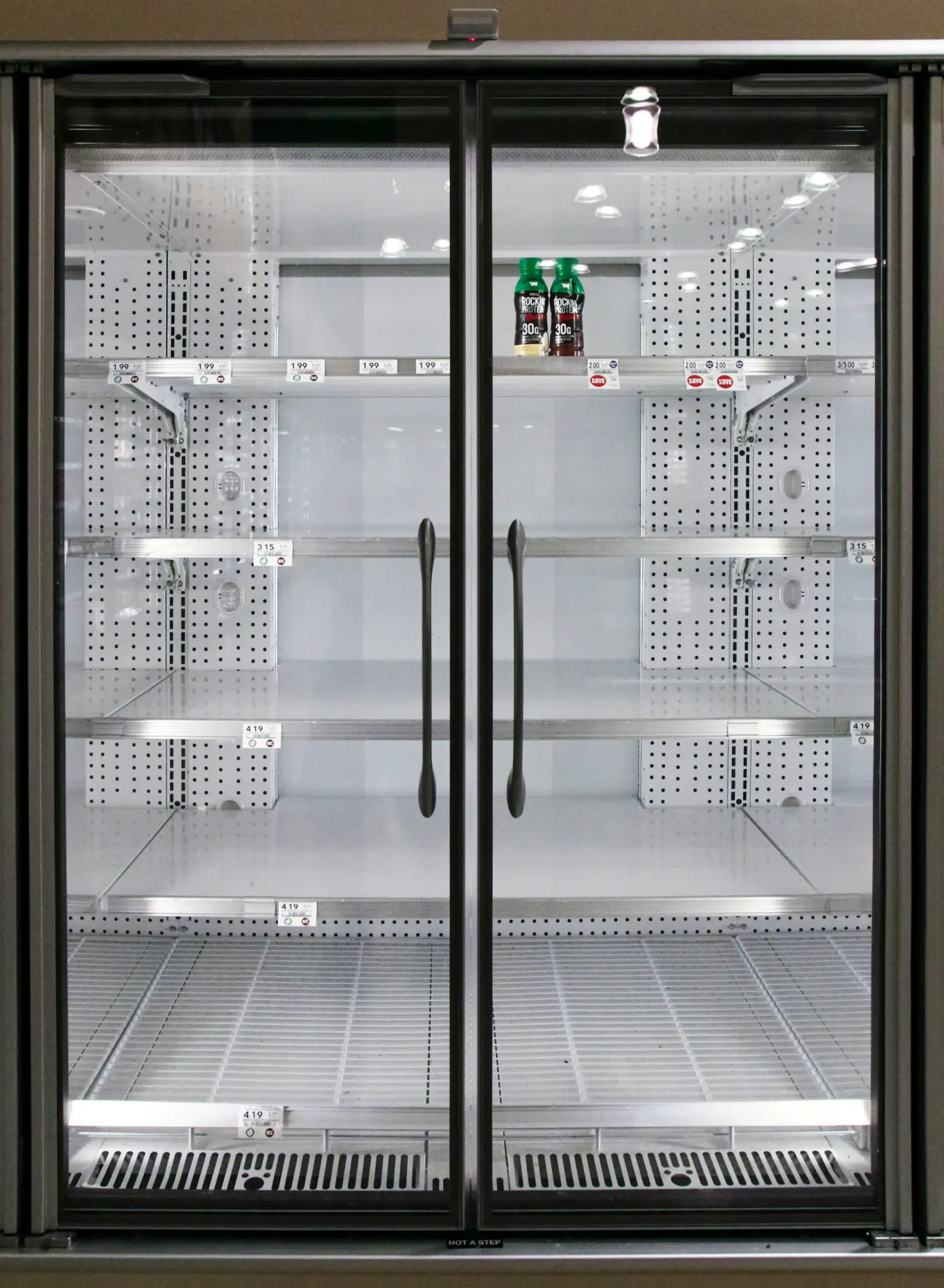 A large glass door refrigerator with shelves in it.