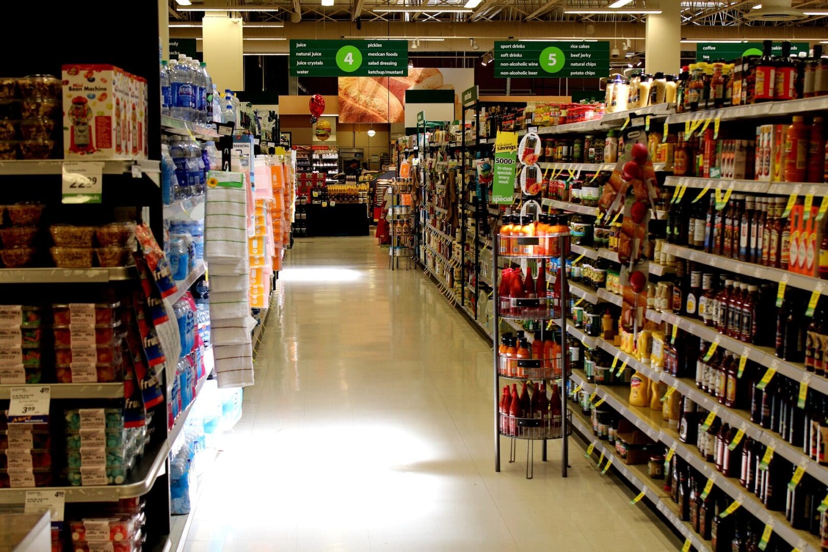 A grocery store aisle with many shelves of food.