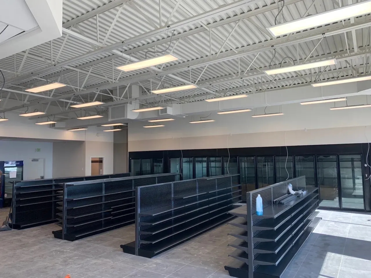 A large empty store with black shelves and white walls.