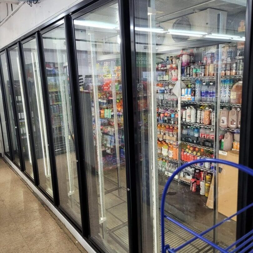 A store with many refrigerators and shelves of beverages.