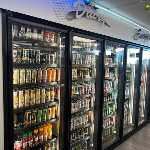 A row of refrigerators filled with lots of drinks.