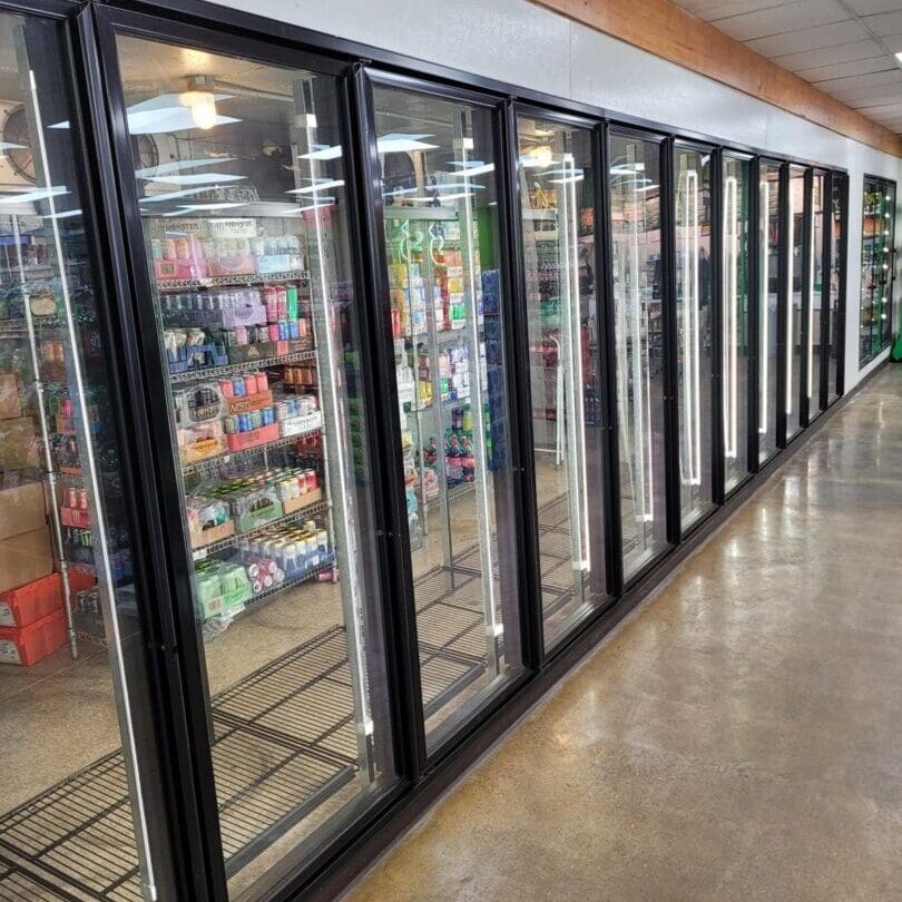 A row of refrigerators in an aisle.