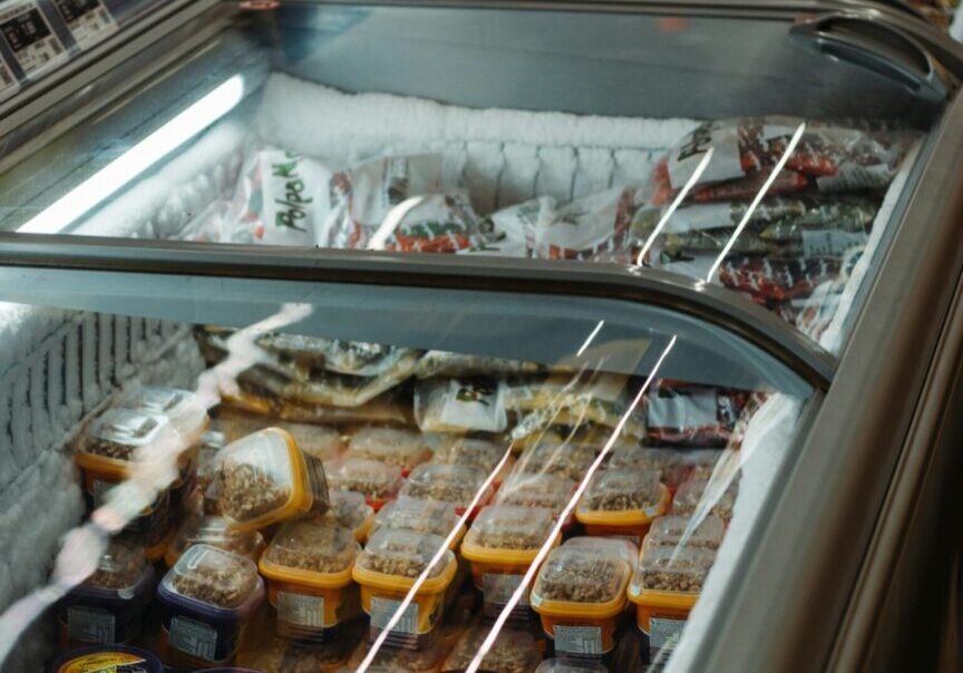 A row of food in an open display case.