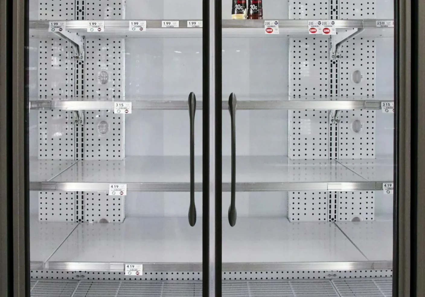 A large glass door refrigerator with shelves in it.