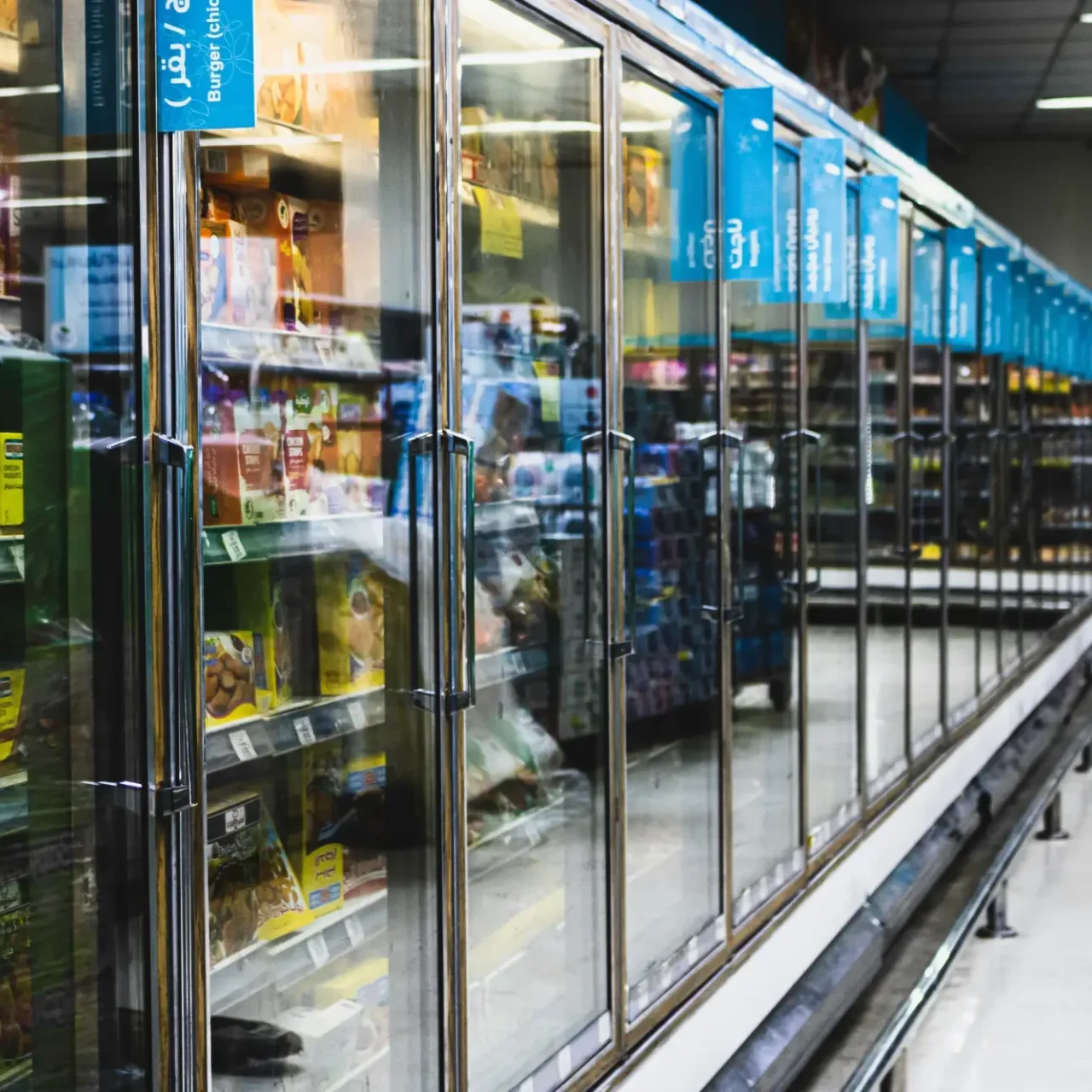 A store with many refrigerators and shelves of food.