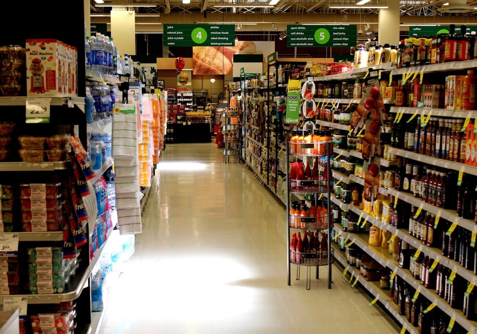 A grocery store aisle with many shelves of food.