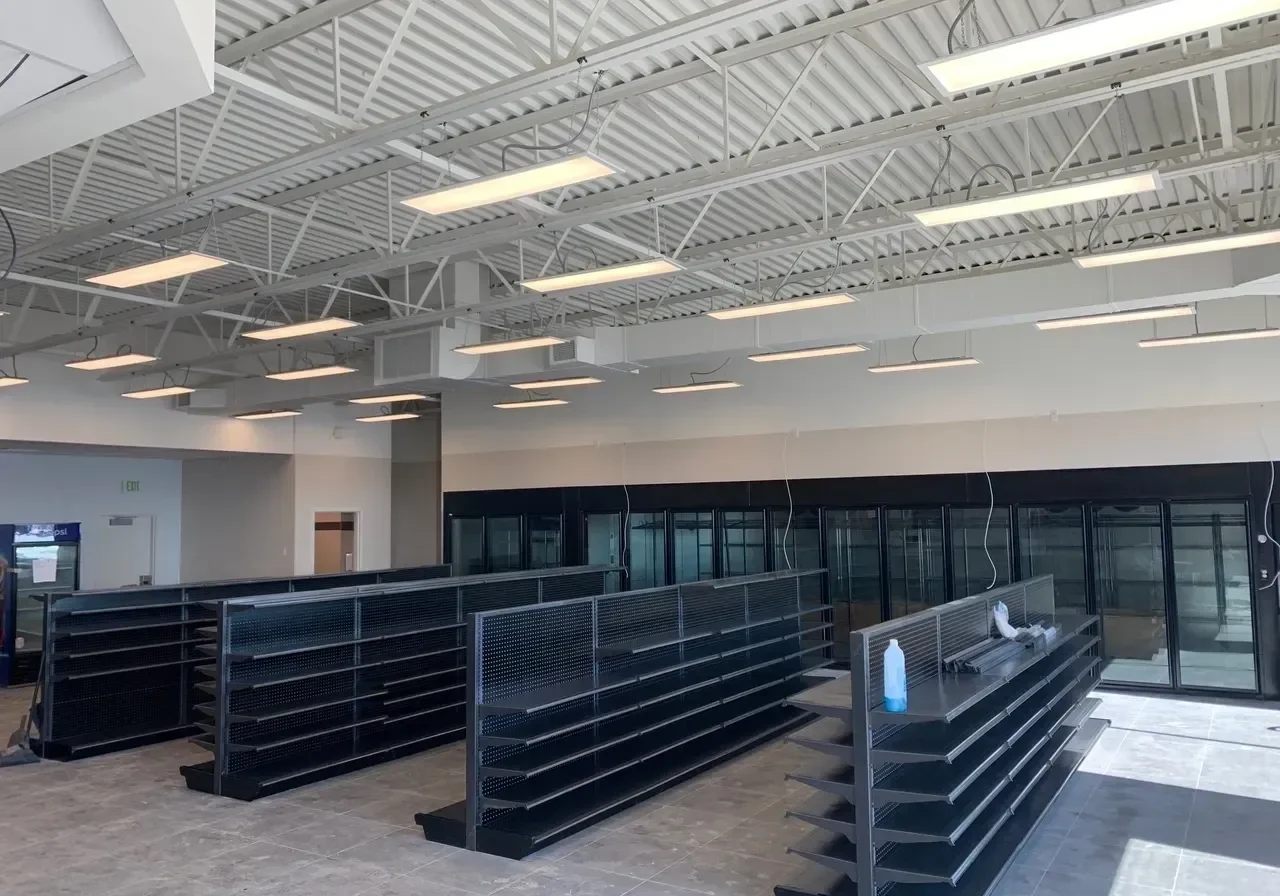 A large empty store with black shelves and white walls.