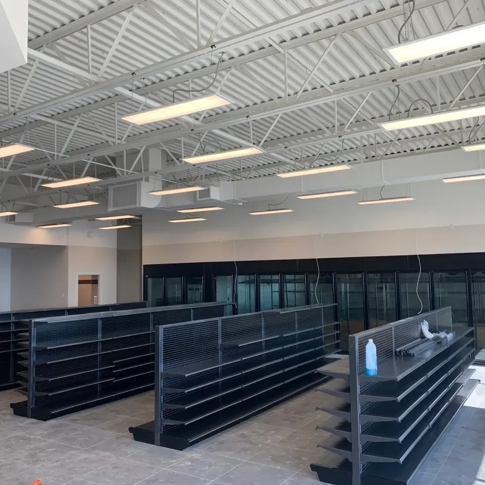 A large empty store with black shelves and white walls.